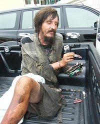 “Michael” shuffles his stack of empty cigarette packs, as police bring him to the station for processing.